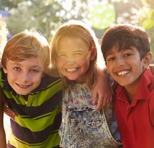 Online-Kurs rund um die Pubertät: Geht's los? Drei Kinder lachen fröhlich in die Kamera
